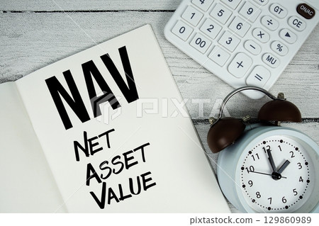 NAV Net Asset Value text on paper notebook page with alarm clock and calculator on wooden background 129860989