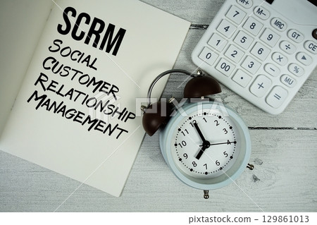 SCRM Social Customer Relationship Management text on paper notebook page with alarm clock and calculator on wooden background SCRM Social Customer Relationship Management text on paper notebook page with alarm clock and calculator on wooden background 129861013