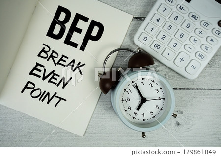 BEP Break Even Point text on paper notebook page with alarm clock and calculator on wooden background BEP Break Even Point text on paper notebook page with alarm clock and calculator on wooden background 129861049