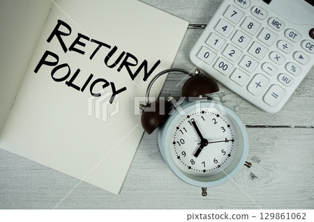 Return Policy text on paper notebook page with alarm clock and calculator on wooden background Return Policy text on paper notebook page with alarm clock and calculator on wooden background 129861062