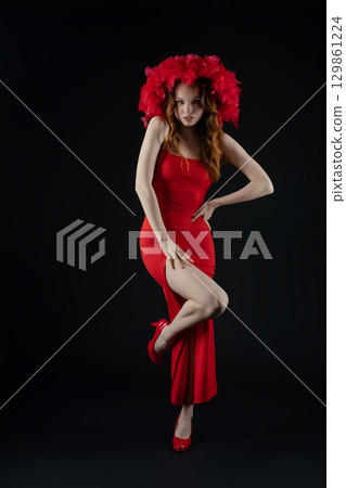 Woman posing with flair and emotion in a striking red dress and vibrant headpiece in a studio setting Woman posing with flair and emotion in a striking red dress and vibrant headpiece in a studio setting 129861224