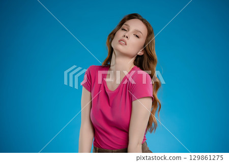 Woman posing with confidence and emotion in a colorful studio setting capturing a moment of self-expression and beauty 129861275