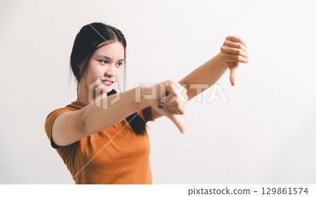 Asian girl expresses dislike, person express negative feeling, concept business complaint from customer ensuring employee satisfaction negative feedback to prevent mental strain customer dislike Asian girl expresses dislike, person express negative feeling, concept business complaint from customer ensuring employee satisfaction negative feedback to prevent mental strain customer dislike 129861574