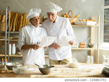 Elderly man and woman checking documents in bakery 129861741