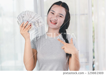 Business, finance and employment, entrepreneur and money concept. Successful young asian office manager, businesswoman showing earned cash, smiling satisfied holding dollars, money dollar bills Business, finance and employment, entrepreneur and money concept. Successful young asian office manager, businesswoman showing earned cash, smiling satisfied holding dollars, money dollar bills 129861989