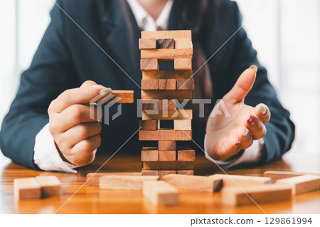 Business risk control concept, Businesswoman protect wooden block fall to planning and strategy in risk to business alternative and prevent. investment insurance business. 129861994