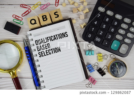 QBS Qualifications Based Selection acronym on notepad, business and financial concept background QBS Qualifications Based Selection acronym on notepad, business and financial concept background 129862087
