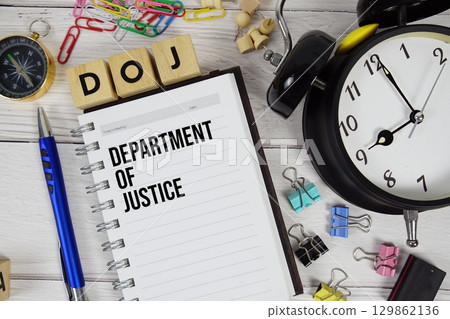 DOJ Department of Justice acronym on notepad, Business and Financial concept 129862136