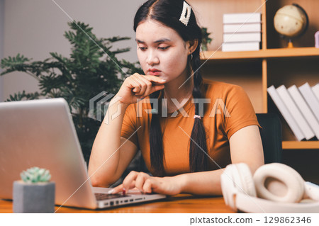 Homeschool Asian girl student learning virtual internet online class from school teacher by remote meeting. Female teaching math by headphone. education concept. student with computer study at school Homeschool Asian girl student learning virtual internet online class from school teacher by remote meeting. Female teaching math by headphone. education concept. student with computer study at school 129862346
