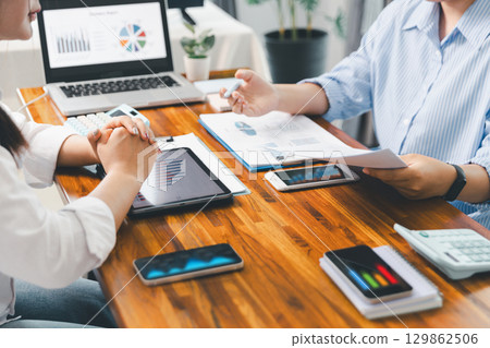 People meeting using laptop computer, calculator, stock market chart paper for analysis plans to improve quality. Team working on project. Analysis business brainstorming corporate smart Concept. 129862506