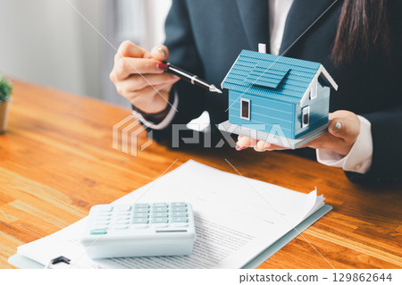 Home loan officer uses calculator with house plan loan real estate or property. important to loan calculator seek real estate, finance insurance advice ensure smart financial decisions for business. Home loan officer uses calculator with house plan loan real estate or property. important to loan calculator seek real estate, finance insurance advice ensure smart financial decisions for business. 129862644