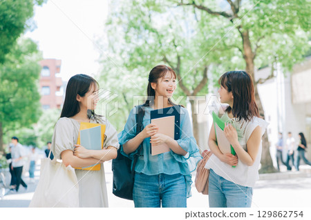 Three college students walking on campus Three college students walking on campus 129862754