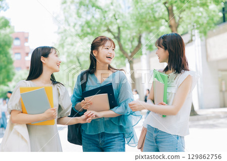 Three college students walking on campus 129862756