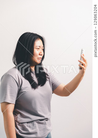 Asian girl expresses dislike, person express negative feeling, concept business complaint from customer ensuring employee satisfaction negative feedback to prevent mental strain customer dislike Asian girl expresses dislike, person express negative feeling, concept business complaint from customer ensuring employee satisfaction negative feedback to prevent mental strain customer dislike 129863204