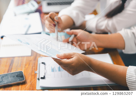Financial business team in office, financial expert analyze business report graph and finance chart at corporate office. Concept of finance economy, banking business and stock market research. Financial business team in office, financial expert analyze business report graph and finance chart at corporate office. Concept of finance economy, banking business and stock market research. 129863207