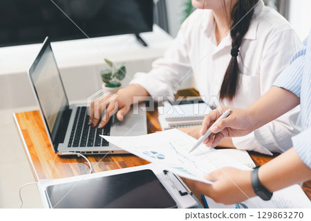 Financial business team in office, financial expert analyze business report graph and finance chart at corporate office. Concept of finance economy, banking business and stock market research. Financial business team in office, financial expert analyze business report graph and finance chart at corporate office. Concept of finance economy, banking business and stock market research. 129863270