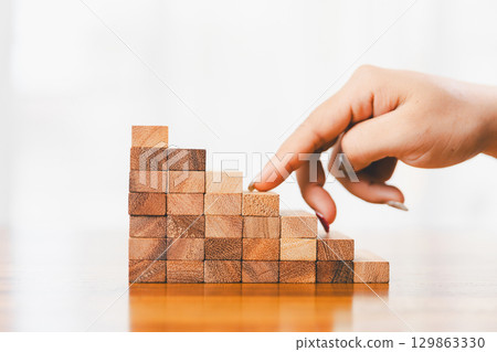 Business risk control concept, Businesswoman protect wooden block fall to planning and strategy in risk to business alternative and prevent. investment insurance business. 129863330