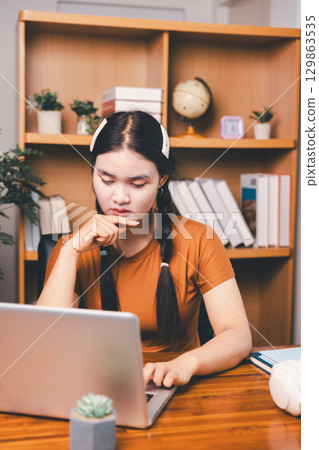 Homeschool Asian girl student learning virtual internet online class from school teacher by remote meeting. Female teaching math by headphone. education concept. student with computer study at school Homeschool Asian girl student learning virtual internet online class from school teacher by remote meeting. Female teaching math by headphone. education concept. student with computer study at school 129863535