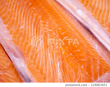Salmon fillet in a vacuum package plastic bag. 129863851