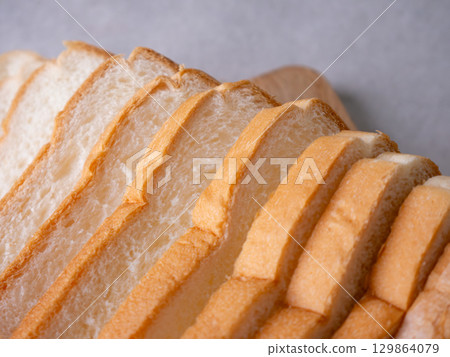 Toasted white bread loaf sliced on white background. Toasted white bread loaf sliced on white background. 129864079