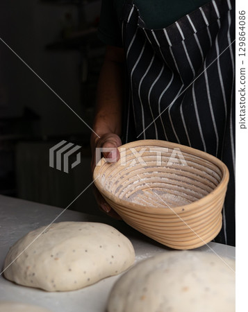 Preparing Banneton Basket for Artisan Sourdough Dough - Breadmaking Process Preparing Banneton Basket for Artisan Sourdough Dough - Breadmaking Process 129864086