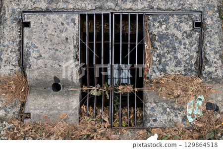 Old Rectangular Urban Drain Cover Made of Metal Grate and Concrete. Old Rectangular Urban Drain Cover Made of Metal Grate and Concrete. 129864518