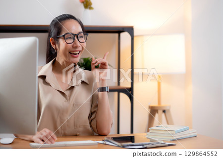 Young asian business woman using desktop computer for success in modern home office. Young asian business woman using desktop computer for success in modern home office. 129864552