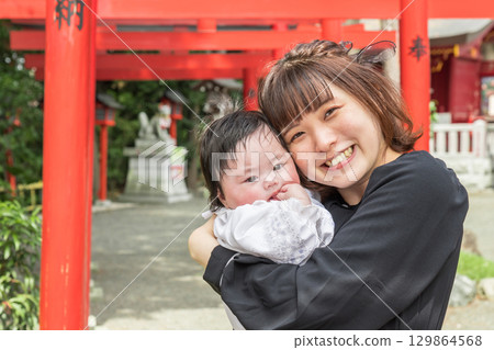 [Mother and baby visiting shrine and red torii gate] 129864568
