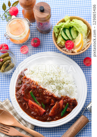 A fragrant tomato curry and rice served with salad - a home-cooked meal 129865486