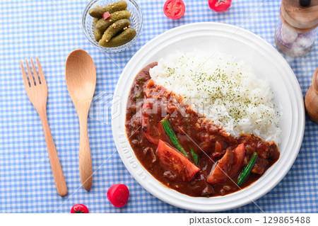 A fragrant tomato curry and rice served with salad - a home-cooked meal 129865488