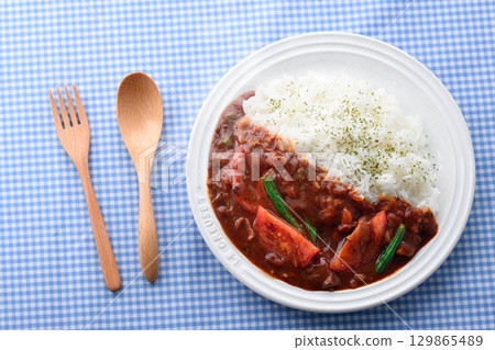 A fragrant tomato curry and rice served with salad - a home-cooked meal 129865489
