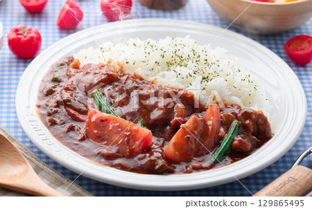 A fragrant tomato curry and rice served with salad - a home-cooked meal 129865495