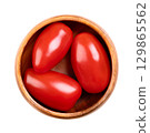 Fresh plum tomatoes, Roma tomatoes in a wooden bowl. Also known as processing or paste tomatoes, oval shaped, and used for canning or producing tomato paste, because of its slender and firm nature. 129865562