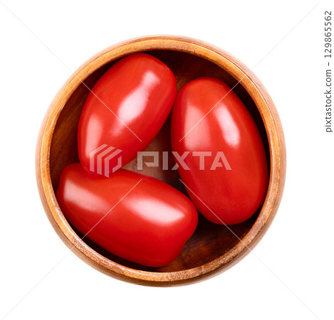 Fresh plum tomatoes, Roma tomatoes in a wooden bowl. Also known as processing or paste tomatoes, oval shaped, and used for canning or producing tomato paste, because of its slender and firm nature. 129865562