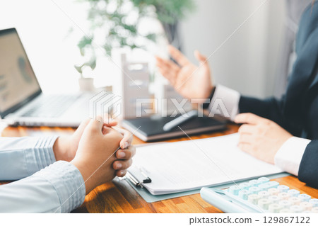 Home loan officer uses calculator with house plan loan real estate or property. important to loan calculator seek real estate, finance insurance advice ensure smart financial decisions for business. Home loan officer uses calculator with house plan loan real estate or property. important to loan calculator seek real estate, finance insurance advice ensure smart financial decisions for business. 129867122