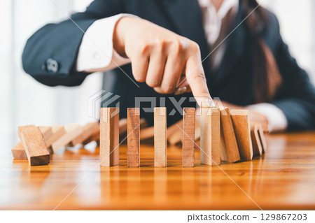 Business risk control concept, Businesswoman protect wooden block fall to planning and strategy in risk to business alternative and prevent. investment insurance business. Business risk control concept, Businesswoman protect wooden block fall to planning and strategy in risk to business alternative and prevent. investment insurance business. 129867203