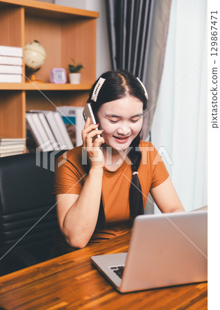 Homeschool Asian girl student learning virtual internet online class from school teacher by remote meeting. Female teaching math by headphone. education concept. student with computer study at school 129867471
