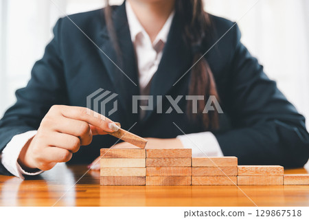 Business risk control concept, Businesswoman protect wooden block fall to planning and strategy in risk to business alternative and prevent. investment insurance business. 129867518
