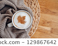 Cup of coffee with maple leaf on table, cozy autumn mood and seasonal atmosphere 129867642