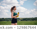 Woman doing yoga and fitness on green grass 129867644
