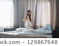 A girl with long hair enjoys a peaceful awakening early in the morning. 129867648