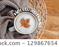 A coffee mug with a cinnamon maple leaf and "Hello Autumn" inscription 129867654