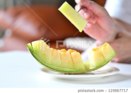 Image of someone about to eat a muskmelon (produced in Kumamoto Prefecture) 129867717