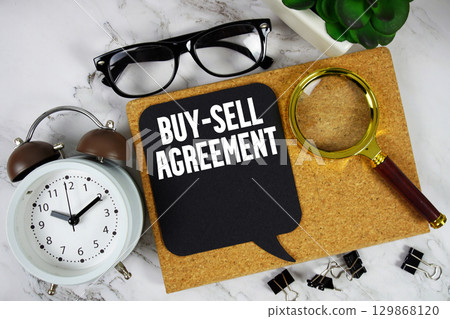 Buy-sell Agreement text with alarm clock and magnifying glass on marble background Buy-sell Agreement text with alarm clock and magnifying glass on marble background 129868120