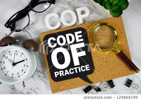 COP Code Of Practice text with alarm clock and magnifying glass on marble background 129868199