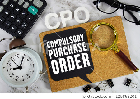 CPO Compulsory Purchase Order text with Calculator, alarm clock and magnifying glass on marble background 129868201