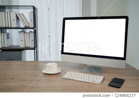 Minimal modern workspace with desktop computer, smartphone, and coffee cup on wooden desk in bright office, ideal for business, technology, and work from home concepts. Minimal modern workspace with desktop computer, smartphone, and coffee cup on wooden desk in bright office, ideal for business, technology, and work from home concepts. 129868237