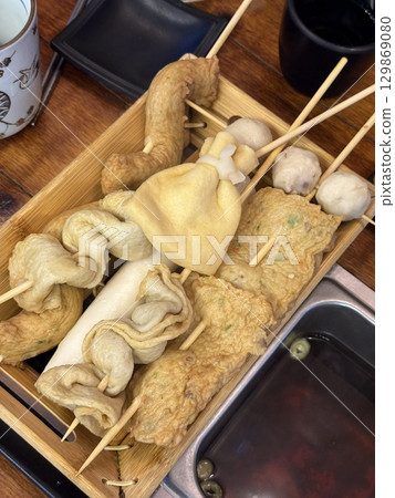 Odeng, a popular Korean street food made from seasoned fish cake, skewered and served in a warm, savory broth. Often paired with dipping sauces, it's a comforting and flavorful snack enjoyed anytime. 129869080