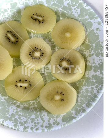 Fresh kiwi slices with vibrant green color and juicy, tangy sweetness, offering a refreshing burst of flavor and a perfect healthy treat in every bright, delicious bite. 129869457