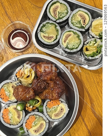 A delicious combination of kimbap and dakgangjeong. The crispy, sweet, and spicy Korean fried chicken pairs perfectly with the savory rice rolls, creating a flavorful and satisfying meal. A delicious combination of kimbap and dakgangjeong. The crispy, sweet, and spicy Korean fried chicken pairs perfectly with the savory rice rolls, creating a flavorful and satisfying meal. 129869563